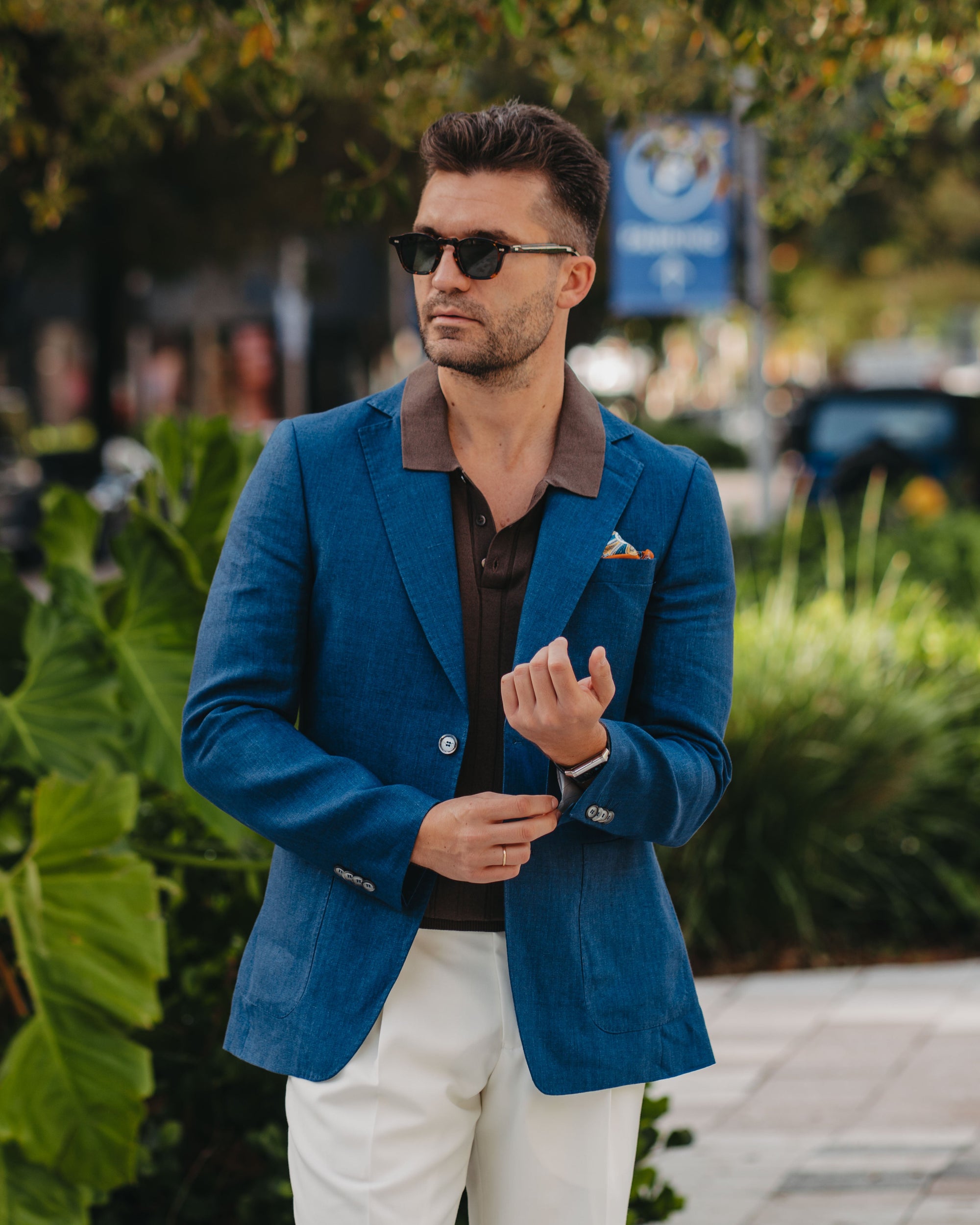 Man wearing a blue blazer and sunglasses outdoors