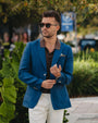 Man wearing a blue blazer and sunglasses outdoors
