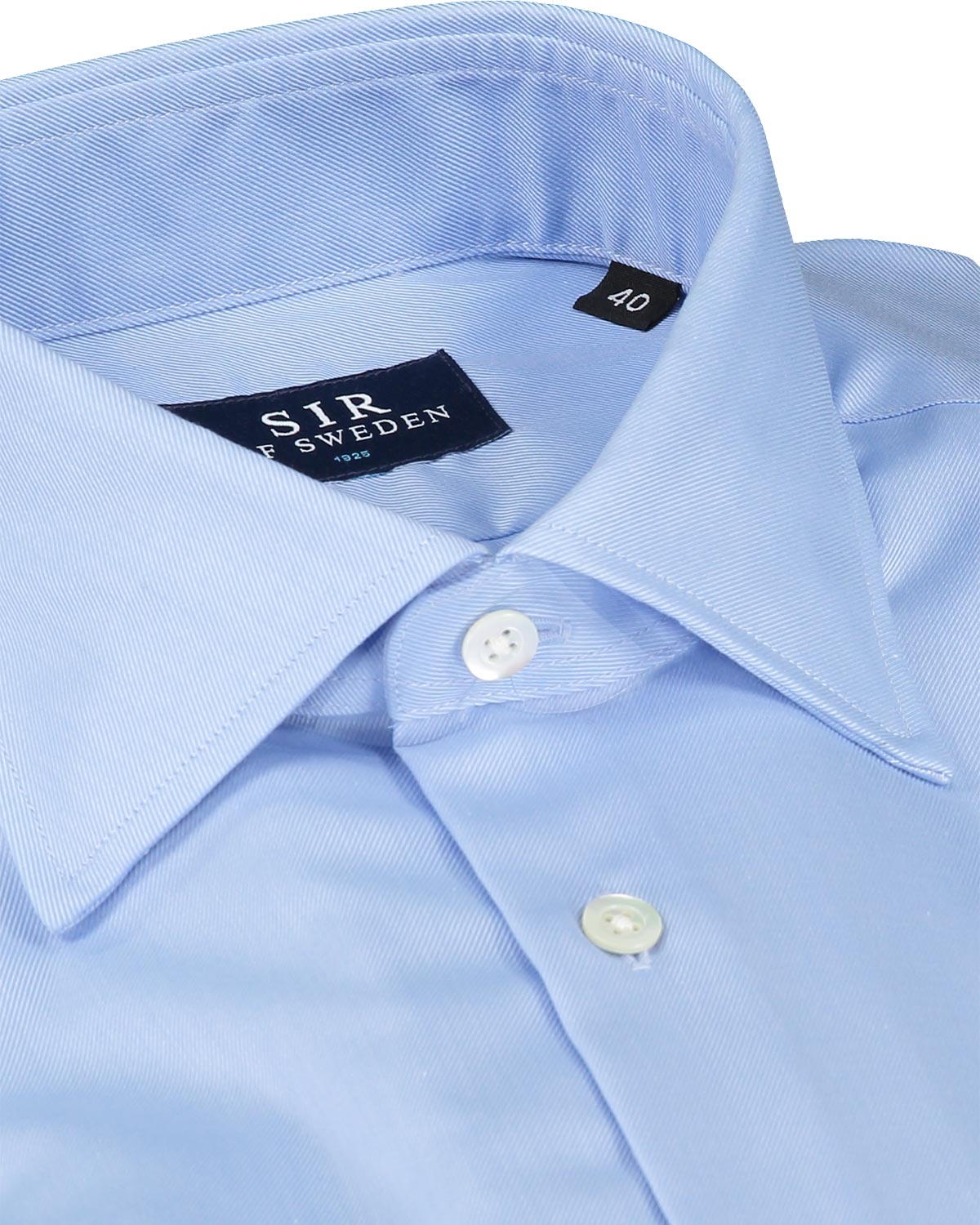 Close-up of a light blue dress shirt with a brand label on the collar.