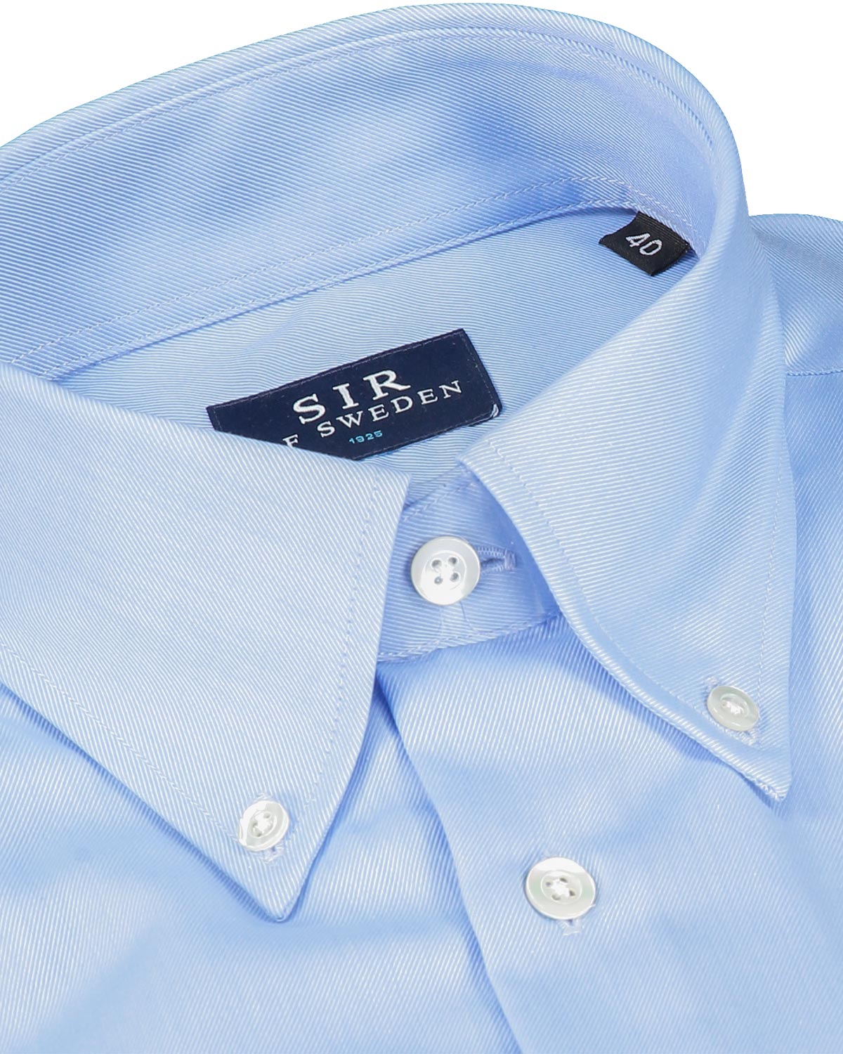 Close-up of a light blue dress shirt with a visible brand label.