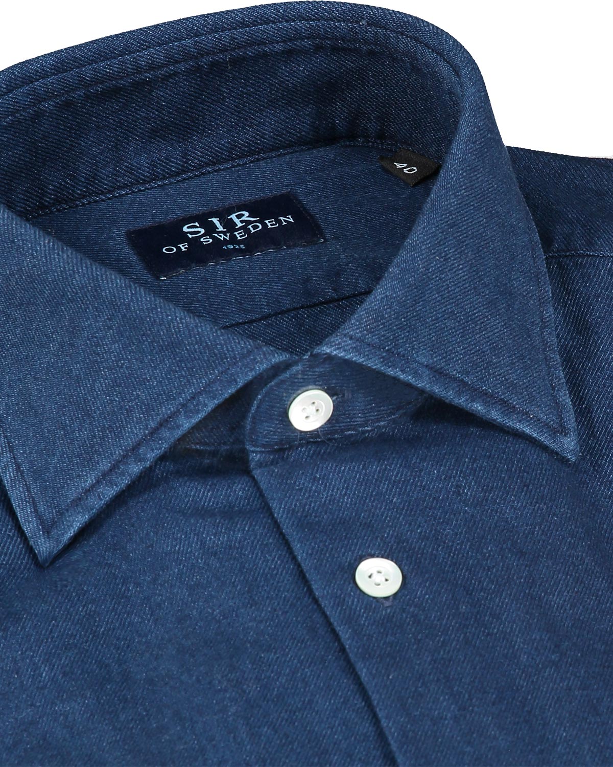 Close-up of a blue denim shirt collar with 'Sir of Sweden' label