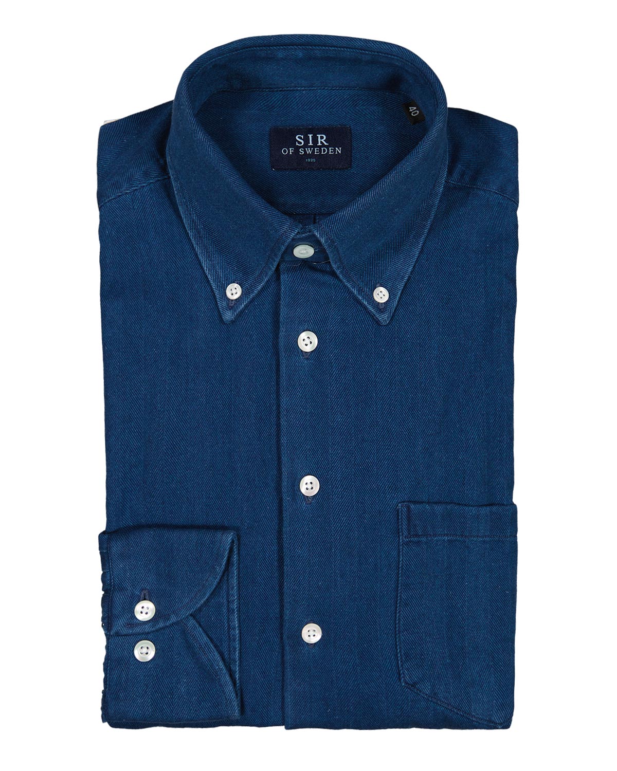 Folded blue herringbone denim shirt on a white background