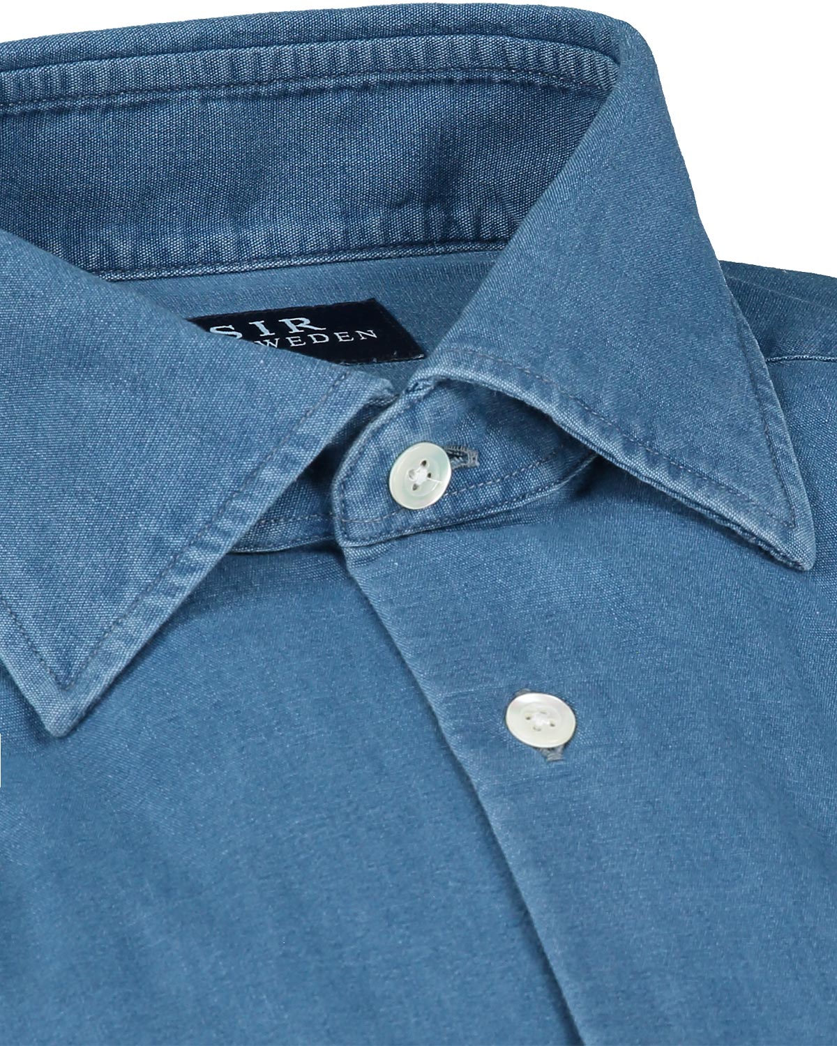 Close-up of a blue denim shirt collar with buttons and 'SIR' brand label.