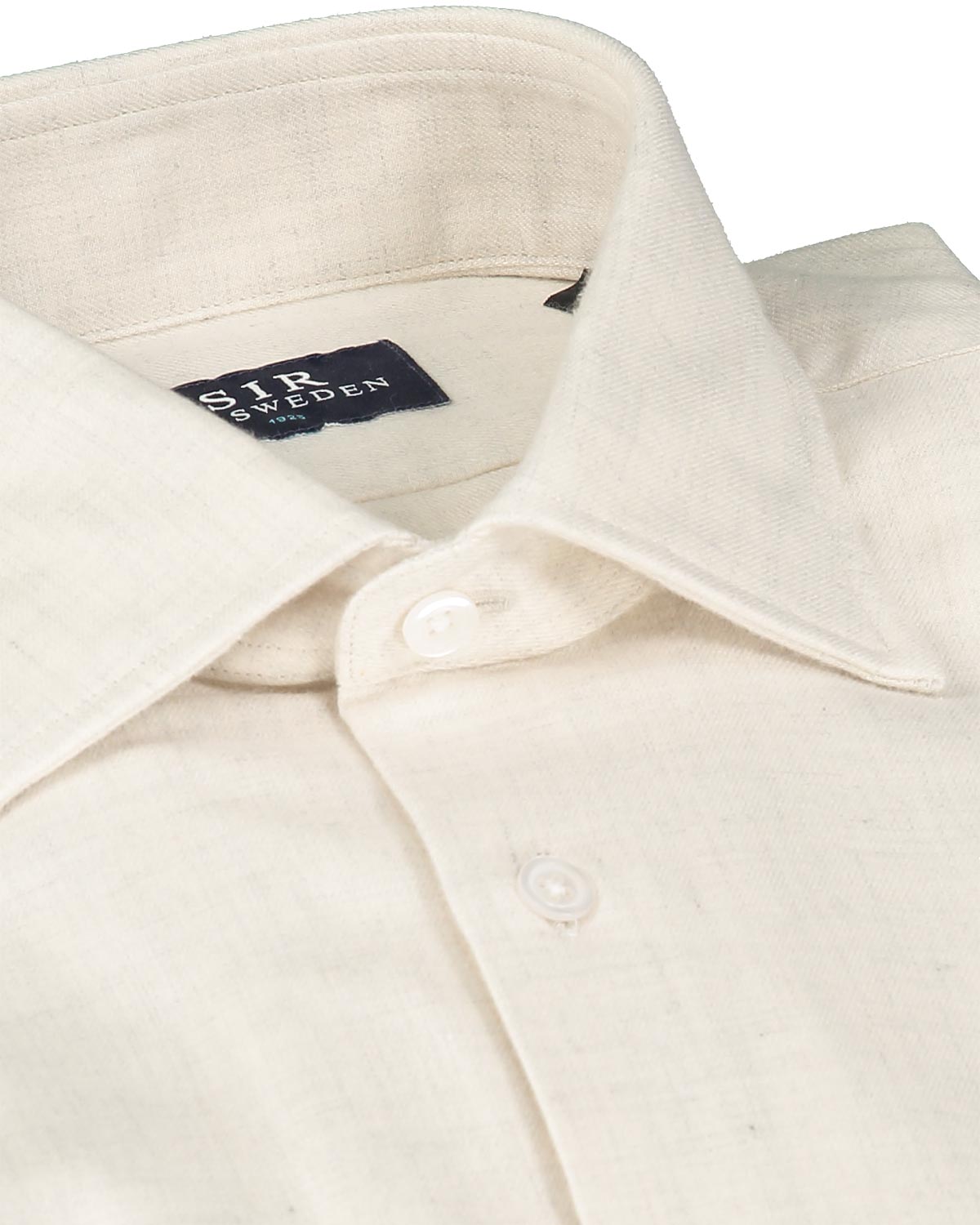 Close-up of a cream-colored flannel shirt with a collar and button details, featuring the SIR of Sweden label.