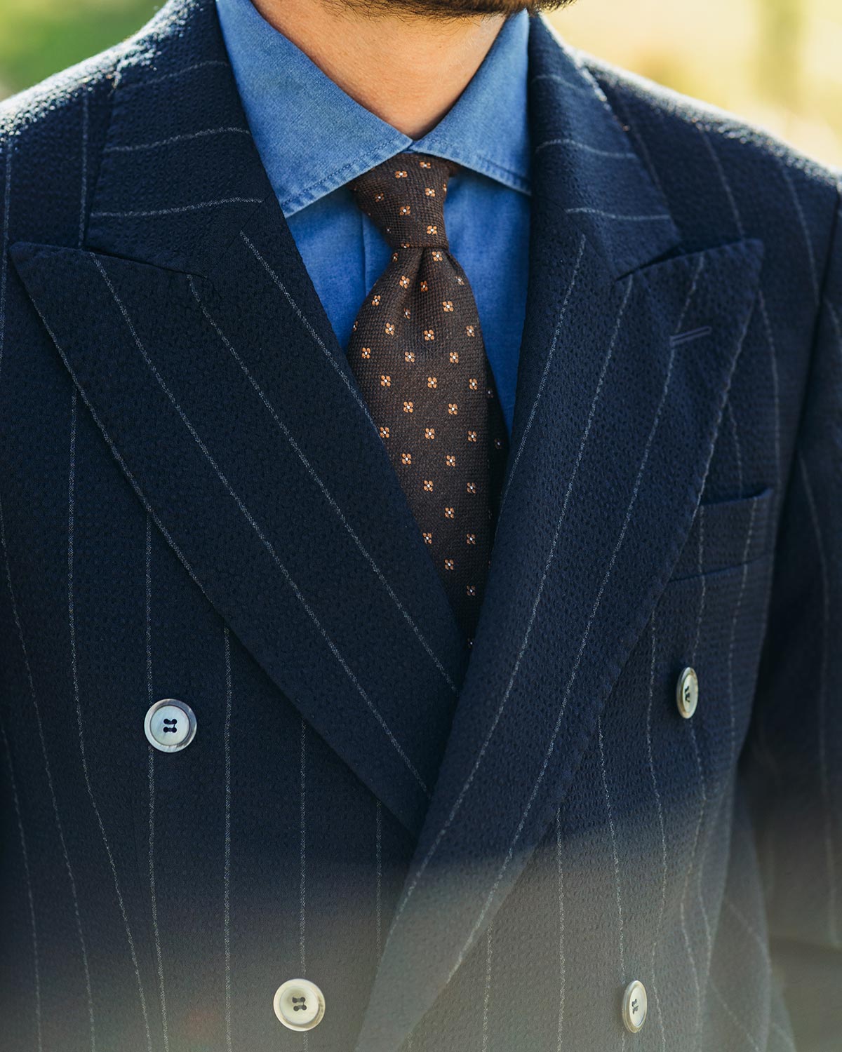 Navy pinstripe suit with blue denim shirt and patterned tie