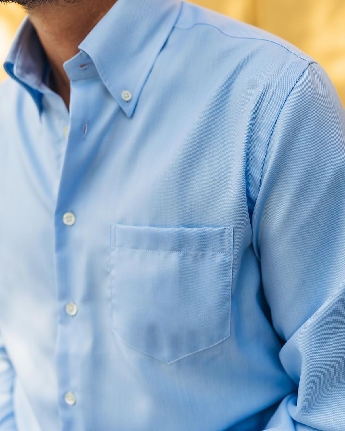 Close-up of a light blue button down shirt with a blurred background